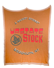 Orange blanket with 'Upstate Stock' branding and text on a white background
