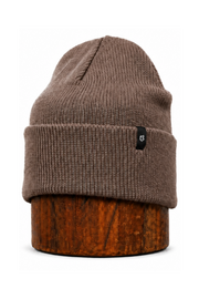 A brown ribbed knit beanie hat displayed on a wooden stand against a plain white background.