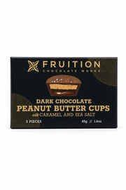 A box of Fruition Chocolate Works Dark Chocolate Peanut Butter Cups with Caramel and Sea Salt, 2 pieces, in a black package with gold lettering and a chocolate cup graphic.