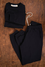 Black outfit with a top and pants on a wooden surface